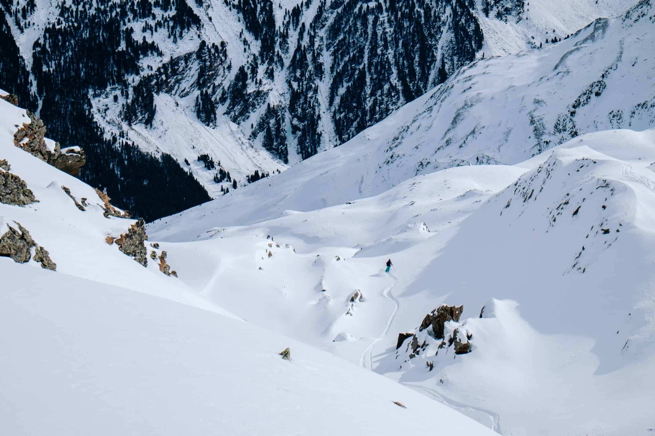 Sci alpinista in discesa lungo un pendio vergine