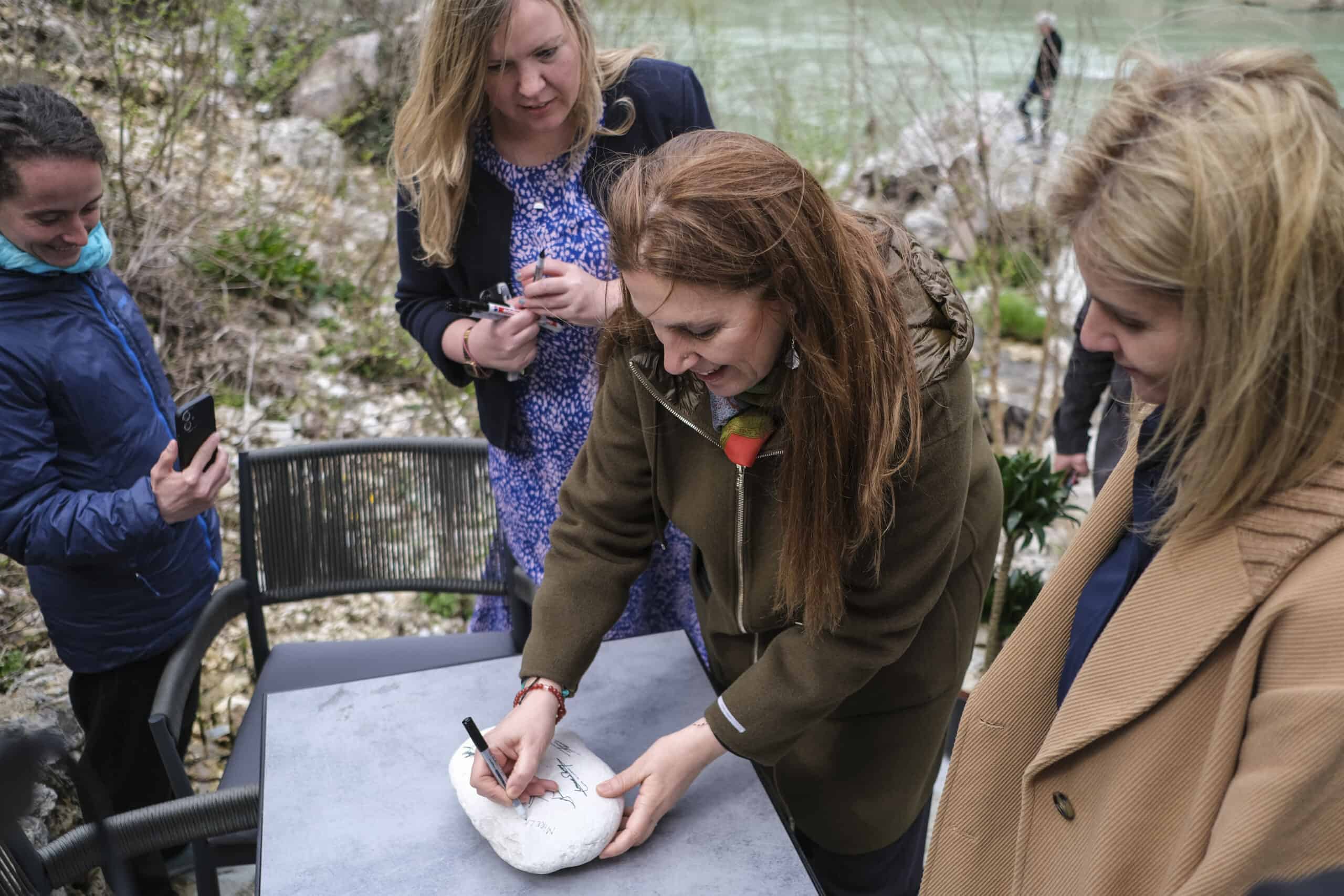 Minister of Tourism and Environment Mirela Kumbaro Furxhi signs a rock to commemorate the declaration of Vjosa Wild River National Park